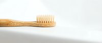 Natural bamboo toothbrush with soft bristles on white background, eco-friendly dental hygiene product for sustainable oral care and zero waste lifestyle.