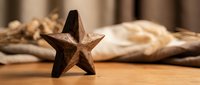 Wooden star decoration on rustic table with fresh bread and nuts creating warm cozy kitchen atmosphere for home decor and cooking themes.