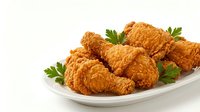 Crispy fried chicken pieces served on white plate with fresh parsley garnish, isolated on white background for food photography and culinary design projects.