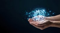 Hands holding glowing brain with digital network connections and sparkling light effects on dark background for technology and innovation concepts.