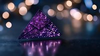 Sparkling purple crystal pyramid with glitter texture against dark background with soft bokeh lights creating magical atmosphere and reflection.