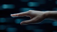 Elegant female hand with shimmering glitter particles on fingers against dark blue bokeh background, creating magical and ethereal atmosphere.
