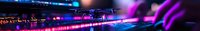 Vibrant purple and blue neon lights illuminate DJ equipment and mixing console in nightclub setting, creating atmospheric electronic music environment.