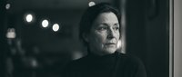 Elderly Caucasian woman with weathered face and intense gaze in dramatic black and white portrait with moody lighting for emotional storytelling concepts.