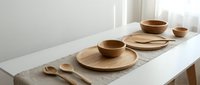 Minimalist wooden dinnerware set with plates, bowls and spoons arranged on white table in bright natural light for modern kitchen and dining decor.
