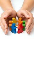 Protective hands surrounding colorful wooden figures representing teamwork, diversity, community support and social unity concepts for business presentations.