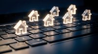 Glowing house icons on laptop keyboard representing digital real estate technology and online property search platforms for modern homebuyers.