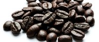 Roasted coffee beans scattered on white background, suitable for beverage packaging, café menus, and food industry marketing materials.