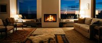 Modern luxury living room with fireplace, comfortable seating, warm lighting, and panoramic windows overlooking sunset landscape. Suitable for interior design, real estate, and home decor projects.