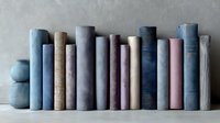Row of vintage books with fabric covers in muted blue, beige, and pink tones arranged on white shelf against neutral wall background.
