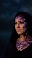 Young woman with mystical constellation face paint featuring purple swirls and glowing dots against dark atmospheric background for fantasy themes.