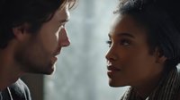 Intimate moment between Caucasian man and African American woman in close-up, sharing emotional connection with soft window light creating atmospheric mood.