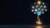 Glowing lightbulb with colorful innovation icons and symbols bursting from top on dark background representing creative ideas and business solutions.
