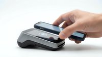 Hand holding smartphone making contactless payment with modern POS terminal on white background. Digital wallet transaction technology for retail commerce.