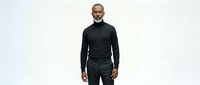Middle-aged man with dark hair and beard wearing black turtleneck and dark pants, standing against white background, isolated for design use on apparel and marketing materials.