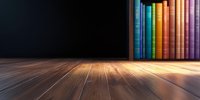 Colorful book spines lined up on wooden shelf with dramatic lighting and shallow depth of field creating atmospheric library or study scene on dark background.