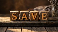 Wooden blocks spelling SAVE on a rustic table, warm tones, cozy background. Great for finance, budgeting, and savings promotion concepts.