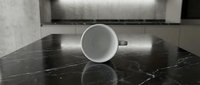 Minimalist white ceramic mug on black marble surface with modern interior background, isolated for product mockup and design projects.