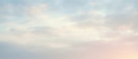 Soft pastel sky with fluffy white clouds in pink and blue hues creating dreamy atmosphere for backgrounds and design projects.