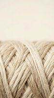 Natural woven rope texture with braided pattern on neutral background for craft and nautical design projects.
