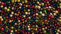 Colorful wooden beads in various sizes and shades scattered on dark background, creating vibrant jewelry making pattern. Craft supplies for DIY accessories.
