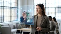 Young professional businesswoman interacting with futuristic holographic data interface displaying charts and analytics in modern office environment.