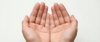 Open cupped hands gesture showing palms up in receiving or offering position against neutral background for prayer meditation charity concepts.