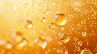 Transparent water drops floating on golden orange background with bokeh effect and sunlight. Macro photography of pure liquid bubbles creates dreamy atmosphere.