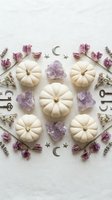 White pumpkins arranged with purple amethyst crystals, dried flowers and celestial symbols in mystical autumn flat lay composition for seasonal decor.