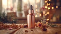 Rose gold cosmetic dropper bottle on wooden surface with autumn leaves and bokeh lights creating cozy seasonal atmosphere for beauty product photography.