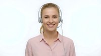 Professional blonde woman customer service representative wearing headset and pink shirt smiling at camera isolated on white background for business use.