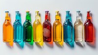 Colorful glass bottles with beverages arranged in row casting shadows on white background, perfect for beverage industry, packaging design and summer drink advertising.