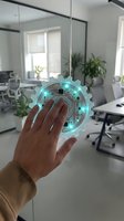 Hand interacting with futuristic holographic gear interface in modern office workspace showcasing digital transformation and innovative technology solutions.