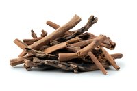 Dried cinnamon sticks and bark pieces in natural brown color isolated on white background, aromatic spice ingredient for cooking and flavoring.