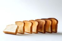 Sliced white bread arranged in gradient showing toasting progression from fresh to dark brown against white background, isolated food photography.
