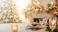 Elegant holiday dining table setting with glowing lights, decorated evergreen garland, and festive centerpiece for seasonal celebrations and entertaining.