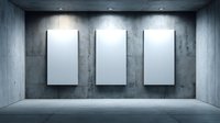Three blank white canvases mounted on concrete wall in modern minimalist gallery space with dramatic lighting for art exhibition or mockup presentation.