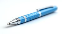 Blue metallic ballpoint pen with chrome accents isolated on white background, selective focus on pen tip showing professional writing instrument details.