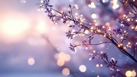 Delicate spring cherry blossom branch with soft pink bokeh lights background creating dreamy atmospheric nature scene for romantic and seasonal designs.