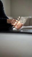 Male professional with medium skin tone holding transparent digital tablet displaying glowing financial charts and graphs, representing data analysis, fintech innovation, and business intelligence for corporate and technology applications.