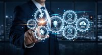 Businessman touching digital interface with glowing technology icons and gears representing innovation, automation and business solutions.