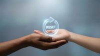 Hands holding glowing reset button symbol representing fresh start, renewal and new beginning concepts for business transformation.