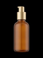 Amber glass pump bottle with gold dispenser isolated on transparent background, ready for cosmetics, skincare, and beauty product packaging design use.