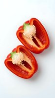 Two halved red bell peppers with seeds and stems visible, isolated on white background. Fresh produce for cooking, nutrition, and food design projects.