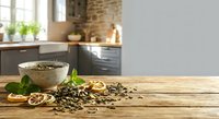 Coffee beans scattered on wooden table with bowl and dried citrus slices in modern kitchen interior for food styling and culinary design projects.