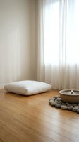 Minimalist meditation space with white cushion, wooden bowl, stones and natural light streaming through sheer curtains for mindfulness practice.