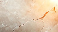 Natural marble stone surface with orange and beige tones showing elegant cracks and veining patterns, suitable for luxury interior design backgrounds.