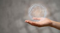 Hand holding glowing wireframe globe representing global connectivity, digital networks, and worldwide business communication for technology and innovation concepts.