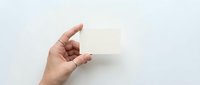 Hand holding blank white business card mockup against clean background for branding and corporate identity design projects.