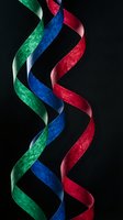 Colorful twisted ribbons in red blue green spiral pattern on black background for celebration decoration party design elements.